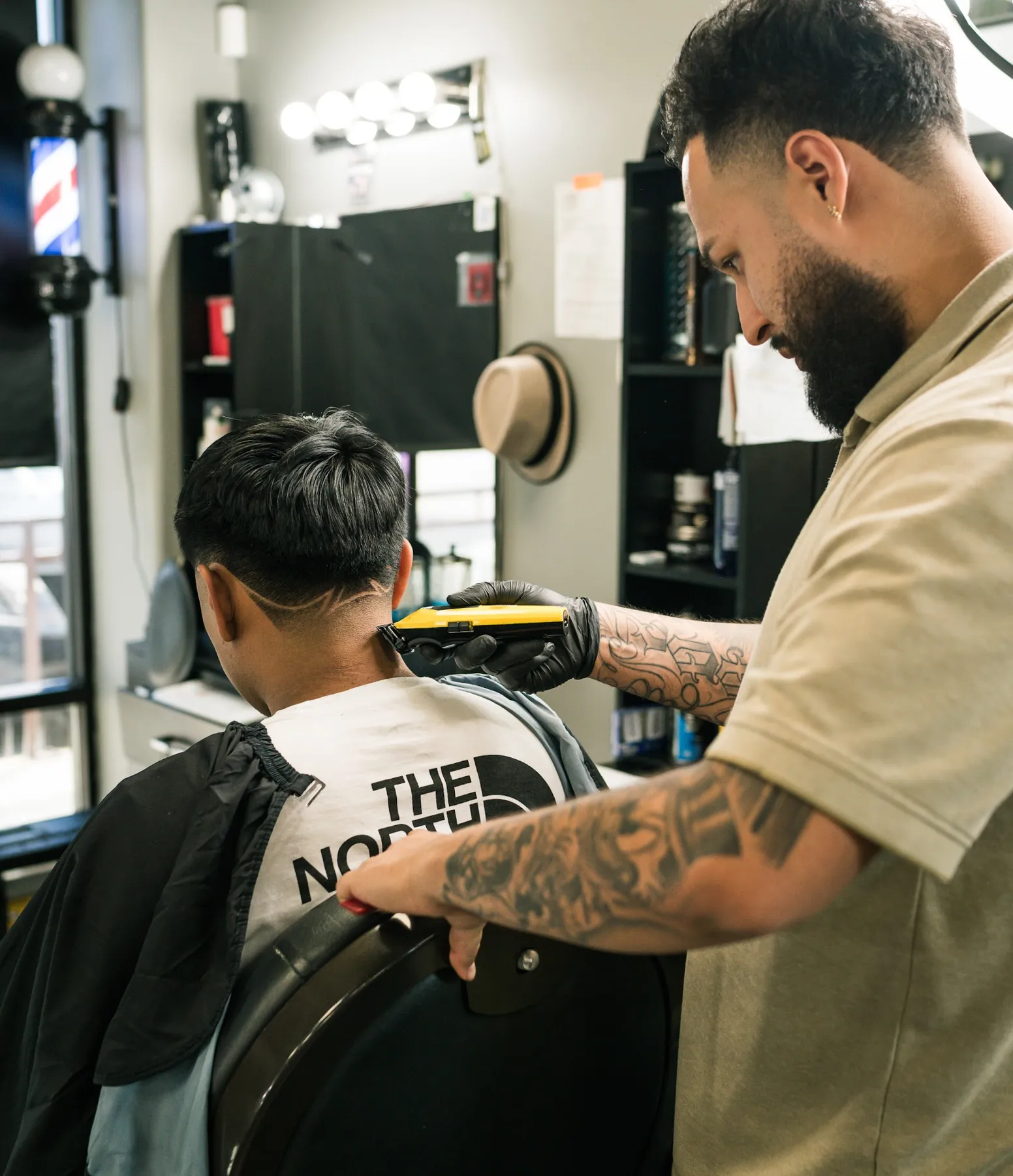 Barber shaping a fade in the chair at VIP Barber Lounge Aurora